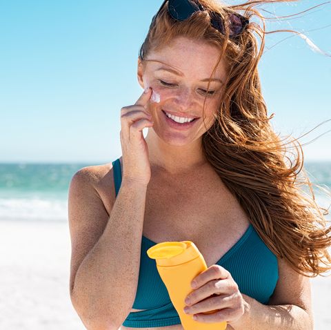 woman applies sunscreen